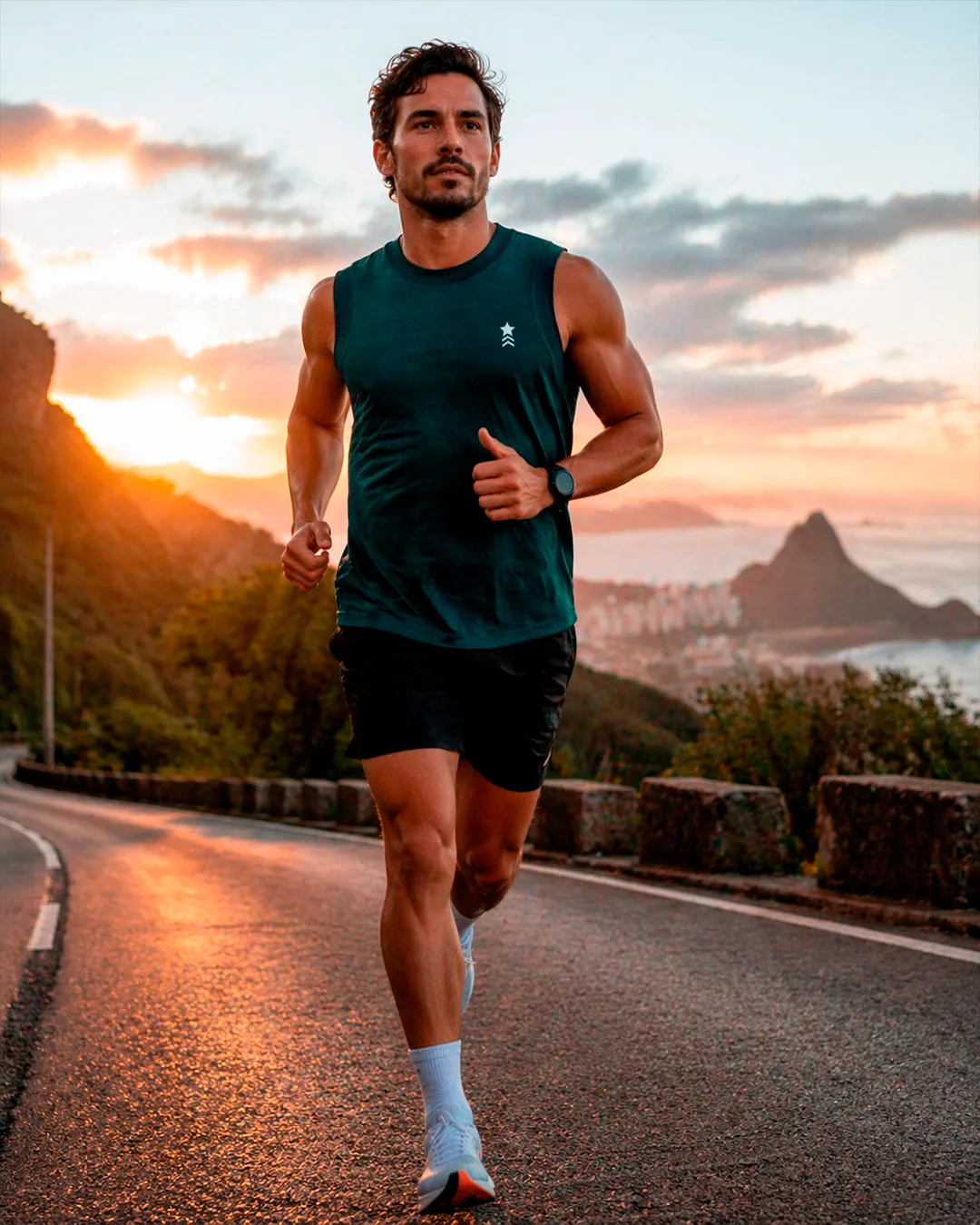 Corredor em estrada litorânea ao pôr do sol com look esportivo
